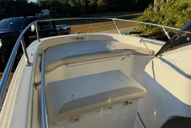 Slide: The Image of 2021 Boston Whaler 130 Super Sport boat interior with cushioned seating and railing. - 8