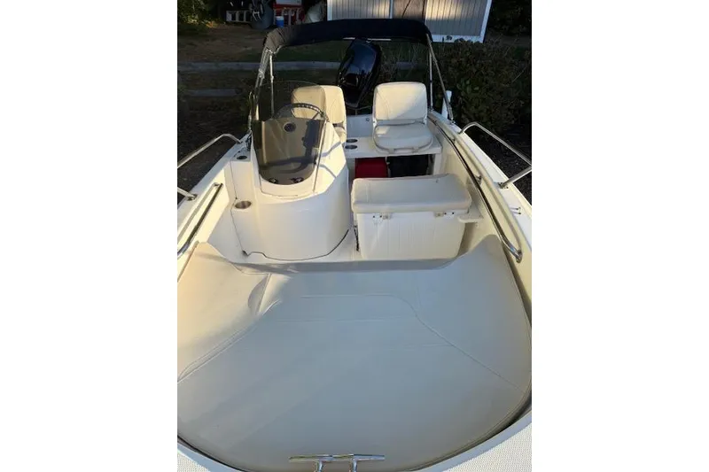 Slide: The Image of 2021 Boston Whaler 130 Super Sport boat interior with seating and steering console. - 9