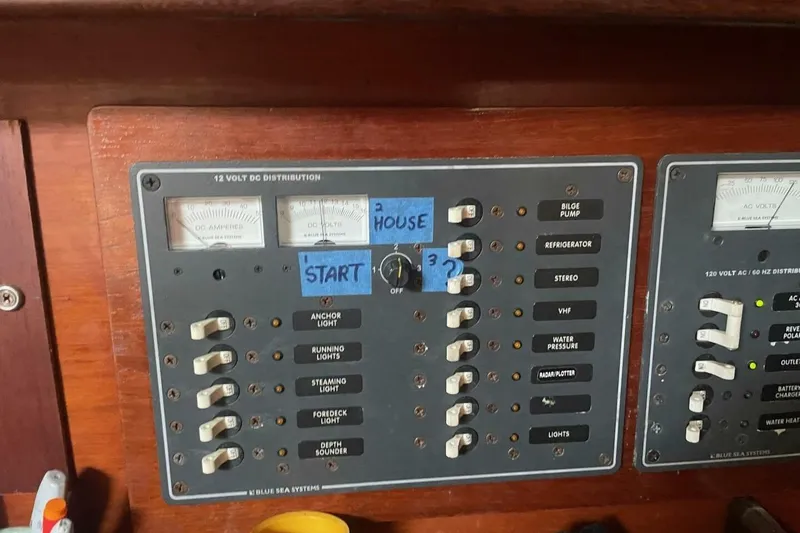 Slide: The Image of Control panel of a 1984 Beneteau First 38.5 sailboat, featuring 12V DC distribution switches. - 12