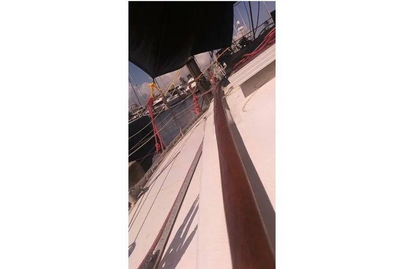 Slide: The Image of 1984 Beneteau First 38.5 sailboat deck view with rigging and marina background. - 19
