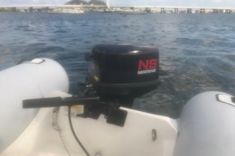 Slide: The Image of Inflatable boat with NS Marine outboard motor on water, near Beneteau First 38.5, 1984. - 22