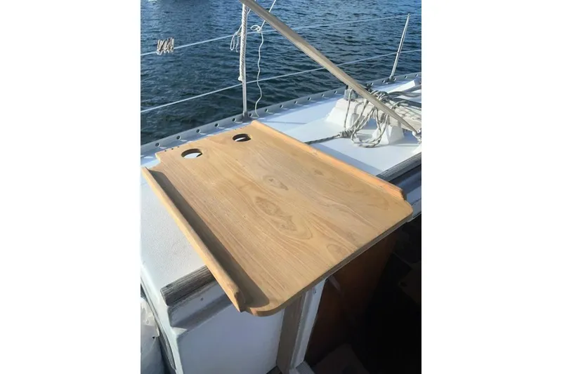 Slide: The Image of Wooden cockpit table on a 1984 Beneteau First 38.5 sailboat, overlooking the water. - 5