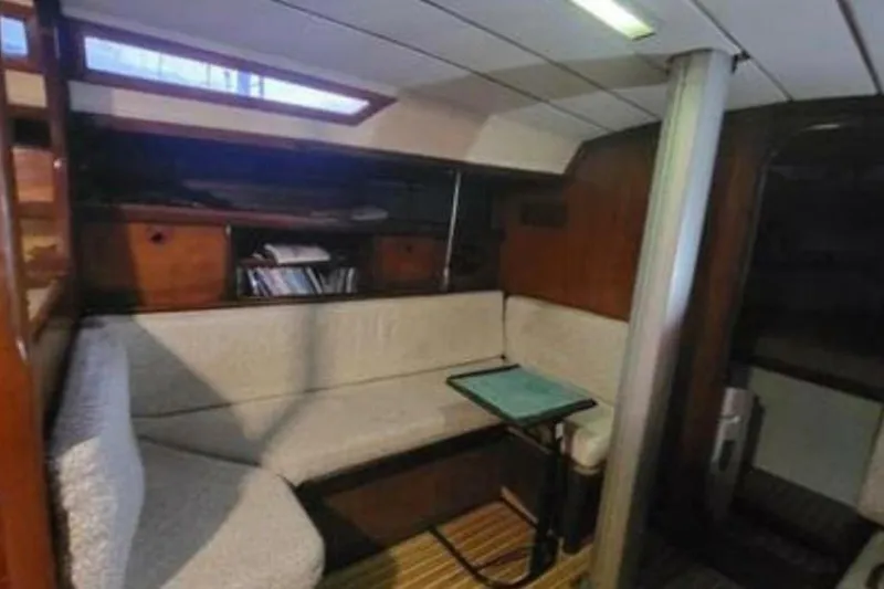 Slide: The Image of Interior of 1984 Beneteau First 38.5 sailboat with cozy seating and wooden accents. - 8
