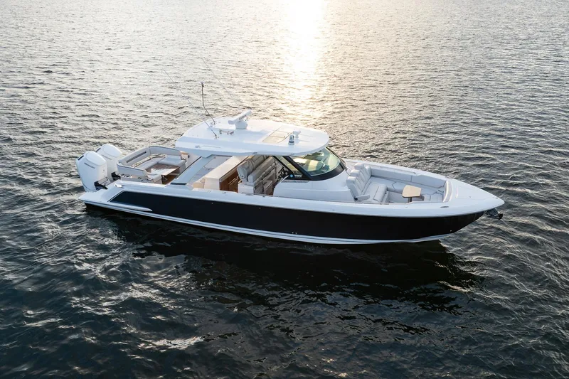 The Image of 2022 Tiara Sport 43 LS luxury boat cruising on calm waters at sunset. - 0