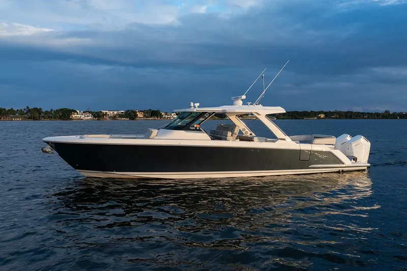Slide: The Image of 2022 Tiara Sport 43 LS luxury boat on calm water at sunset. - 1