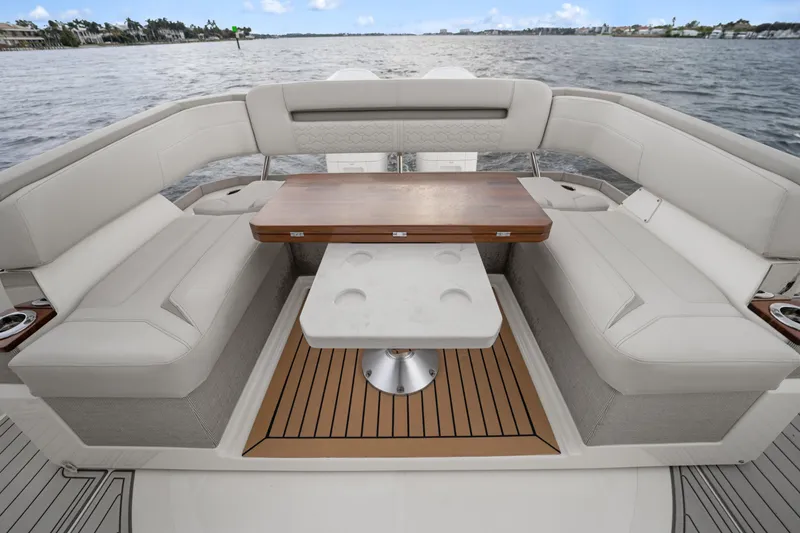 Slide: The Image of Luxury seating area on 2022 Tiara Sport 43 LS boat with elegant table and scenic water view. - 15
