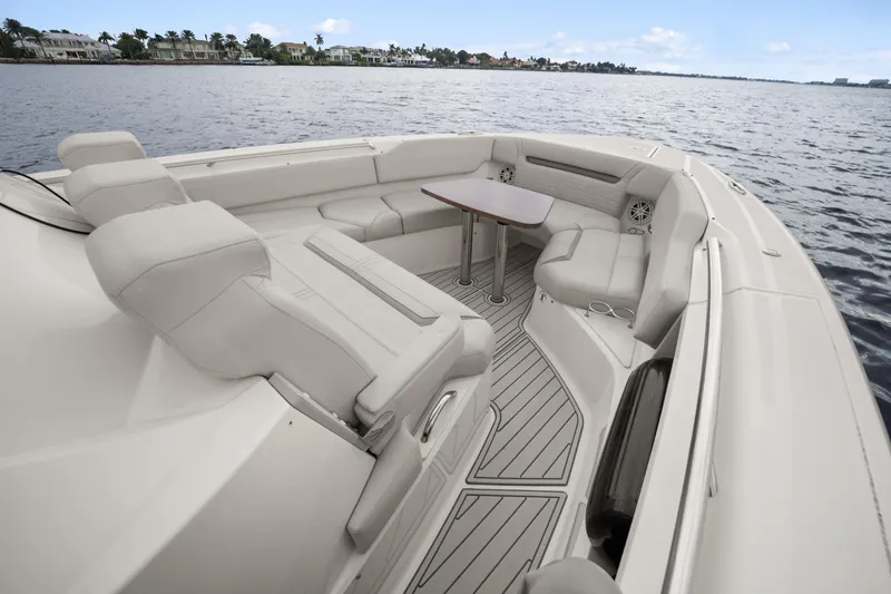 Slide: The Image of 2022 Tiara Sport 43 LS boat interior with luxurious seating and table on calm water. - 17