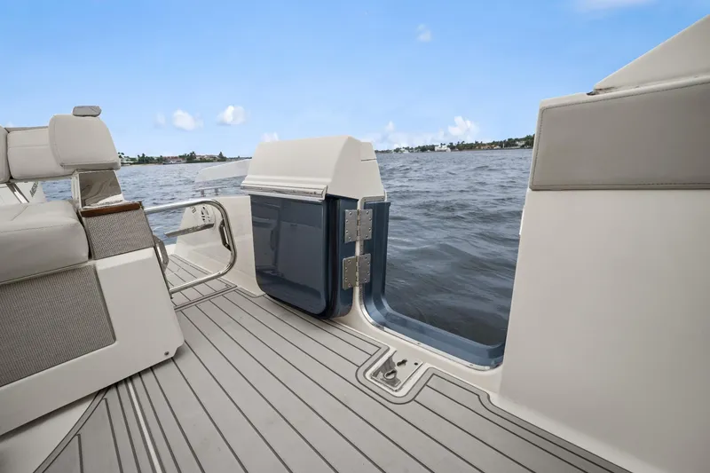 Slide: The Image of 2022 Tiara Sport 43 LS boat deck with open side door, overlooking water. - 18
