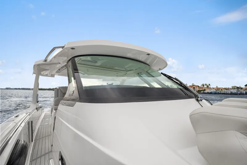 Slide: The Image of 2022 Tiara Sport 43 LS luxury boat on water, showcasing sleek design and spacious deck. - 23