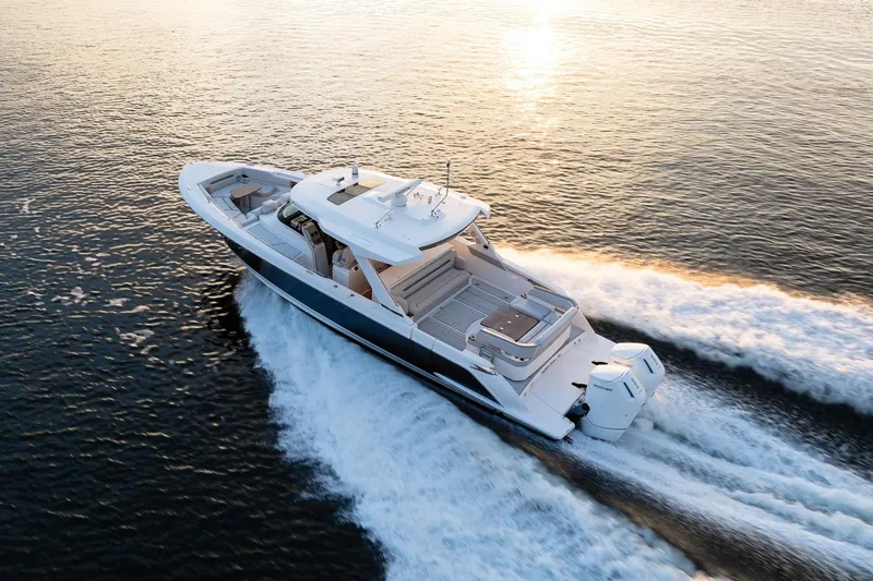 Slide: The Image of 2022 Tiara Sport 43 LS luxury boat cruising on open water at sunset. - 32