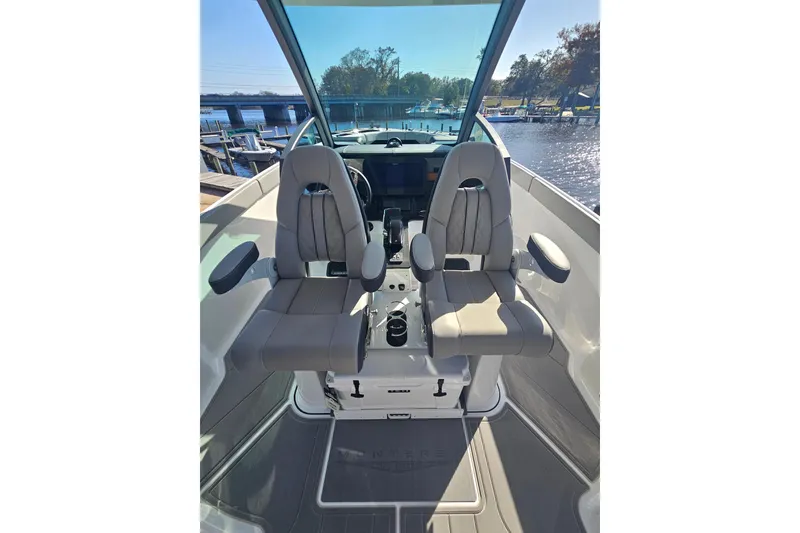 Slide: The Image of 2026 Monterey Elite 27 OB boat interior with dual captain seats and waterfront view. - 11