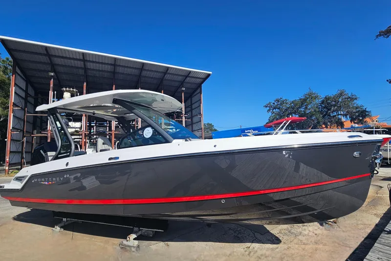 Slide: The Image of 2026 Monterey Elite 27 OB boat with sleek design, docked under clear blue sky. - 2