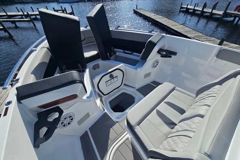 Slide: The Image of 2026 Monterey Elite 27 OB boat interior with luxurious seating and cup holders by the water. - 24