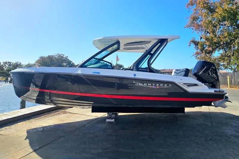 Slide: The Image of 2026 Monterey Elite 27 OB boat docked, featuring sleek black and white design with red accents. - 3