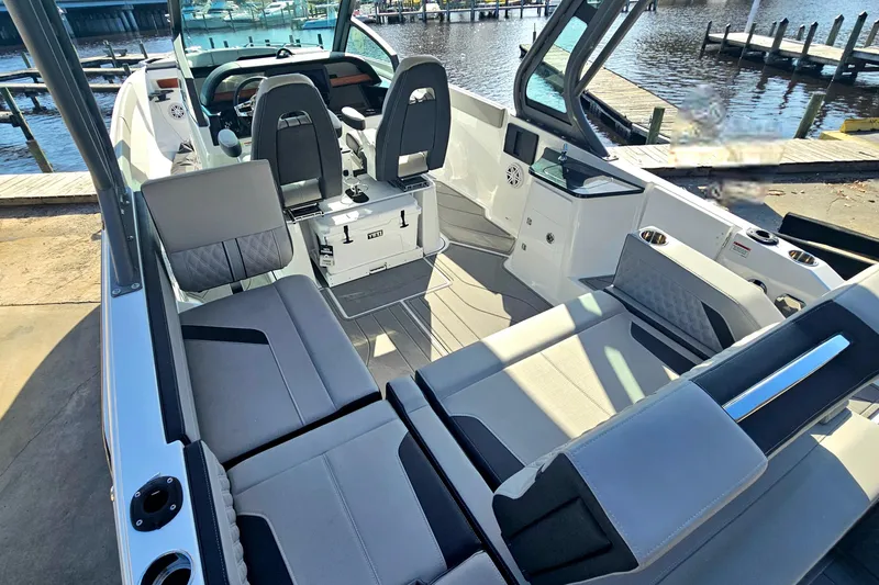 Slide: The Image of 2026 Monterey Elite 27 OB boat interior with modern seating and waterfront view. - 8