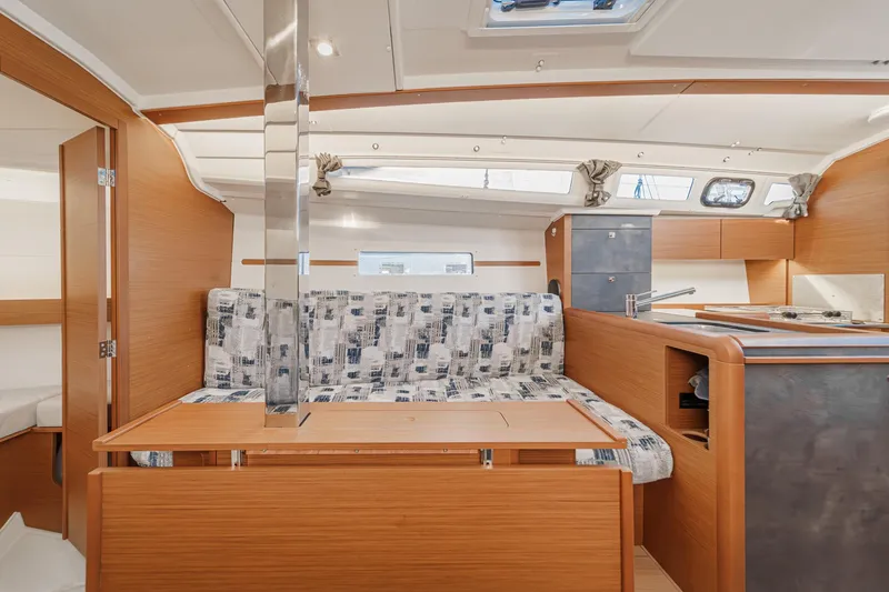 Slide: The Image of Interior of 2022 Jeanneau Sun Odyssey 349 sailboat with modern wood finish and patterned seating. - 12
