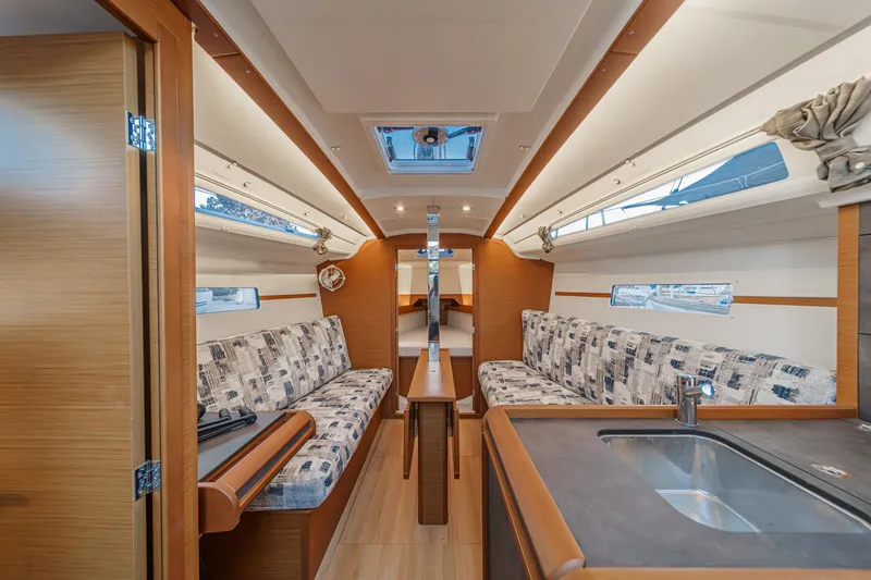 Slide: The Image of Interior of 2022 Jeanneau Sun Odyssey 349 sailboat, featuring modern seating and compact kitchen area. - 19