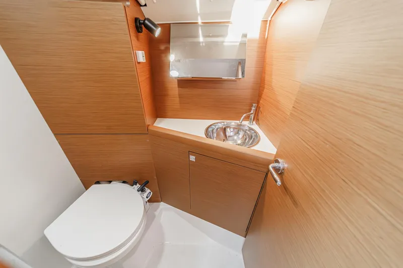 Slide: The Image of 2022 Jeanneau Sun Odyssey 349 bathroom with modern sink and toilet, wooden cabinetry. - 29
