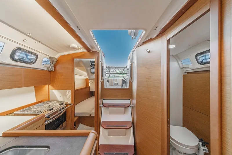 Slide: The Image of Interior of 2022 Jeanneau Sun Odyssey 349 sailboat, featuring kitchen, seating, and bathroom. - 39