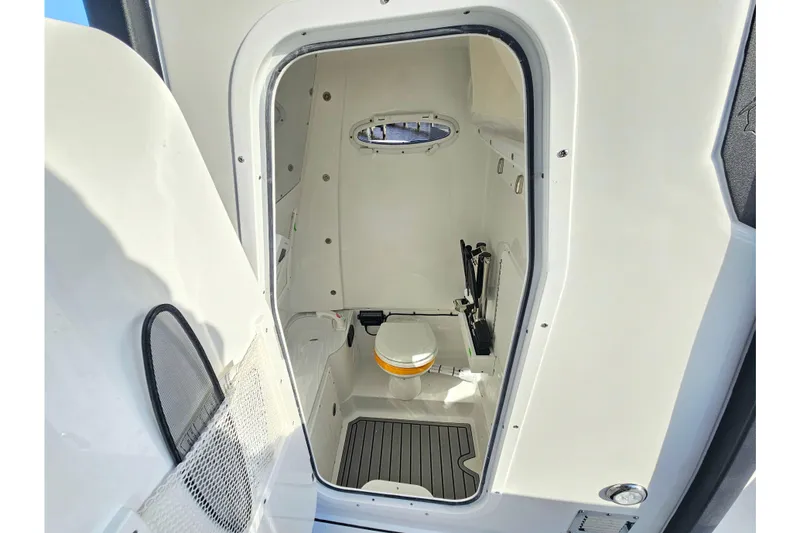 Slide: The Image of 2026 Sea Hunt Ultra 285 SE boat interior with compact marine toilet and storage. - 19