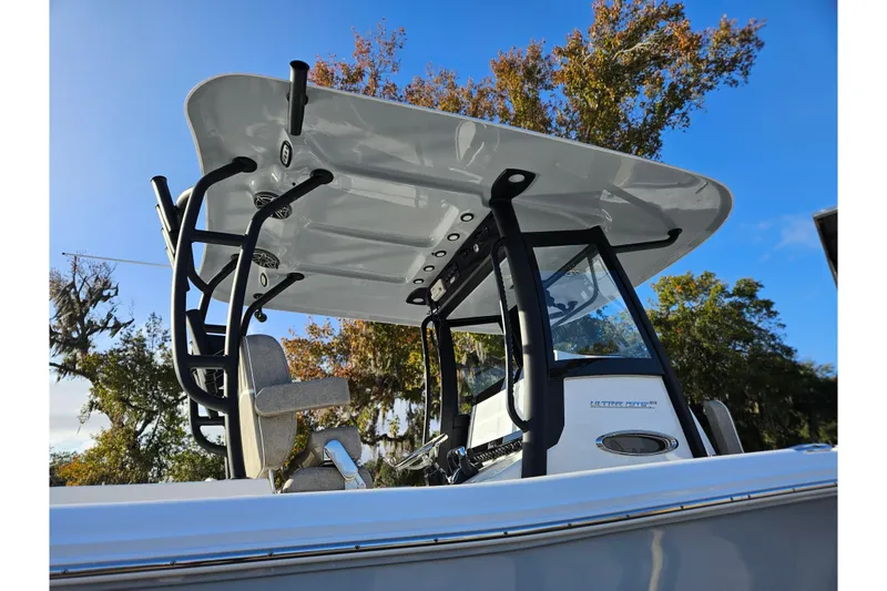 Slide: The Image of 2026 Sea Hunt Ultra 285 SE boat with T-top and console, under clear blue sky. - 5
