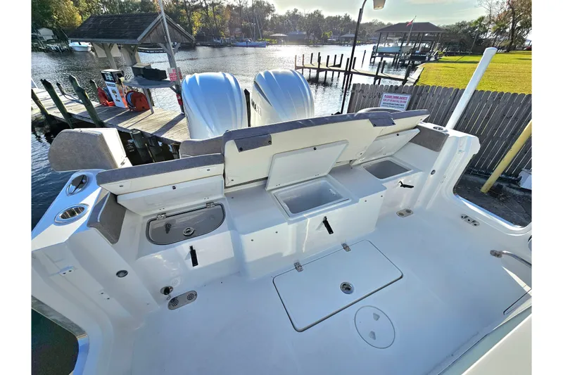 Slide: The Image of 2026 Sea Hunt Ultra 285 SE boat deck with storage compartments and dual engines. - 8