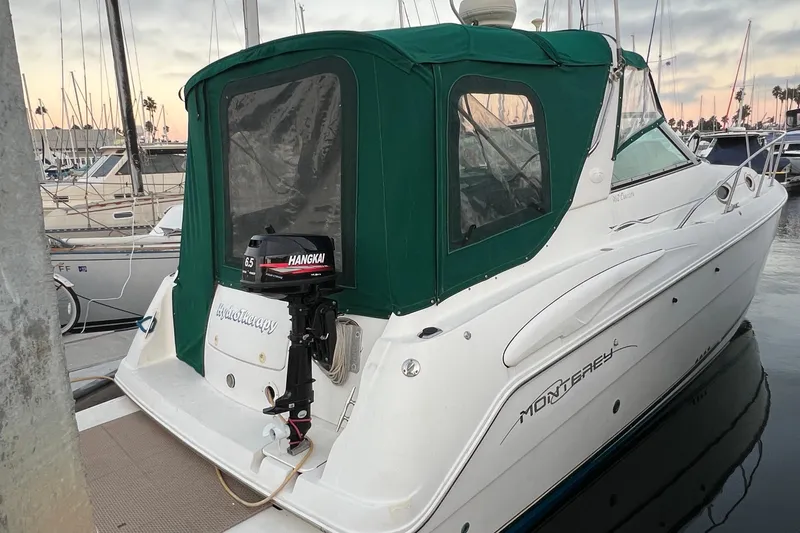 Slide: The Image of 2000 Monterey 302 Cruiser docked, featuring green canopy and Hangkai outboard motor. - 10