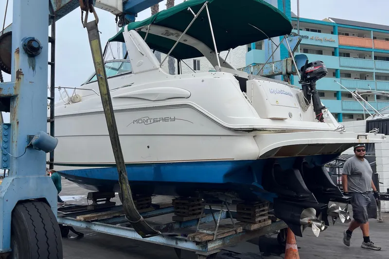 Slide: The Image of 2000 Monterey 302 Cruiser on lift, marina background, maintenance setting. - 19