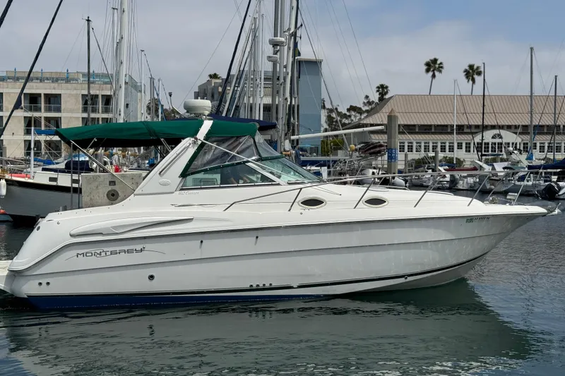 Slide: The Image of 2000 Monterey 302 Cruiser docked at marina with green canopy. - 2