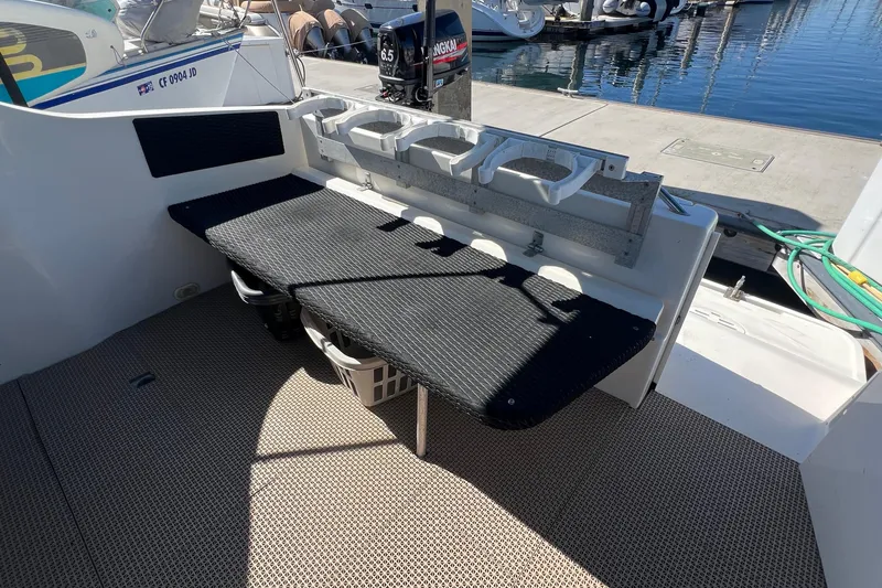 Slide: The Image of 2000 Monterey 302 Cruiser boat deck with seating and cup holders at marina. - 24