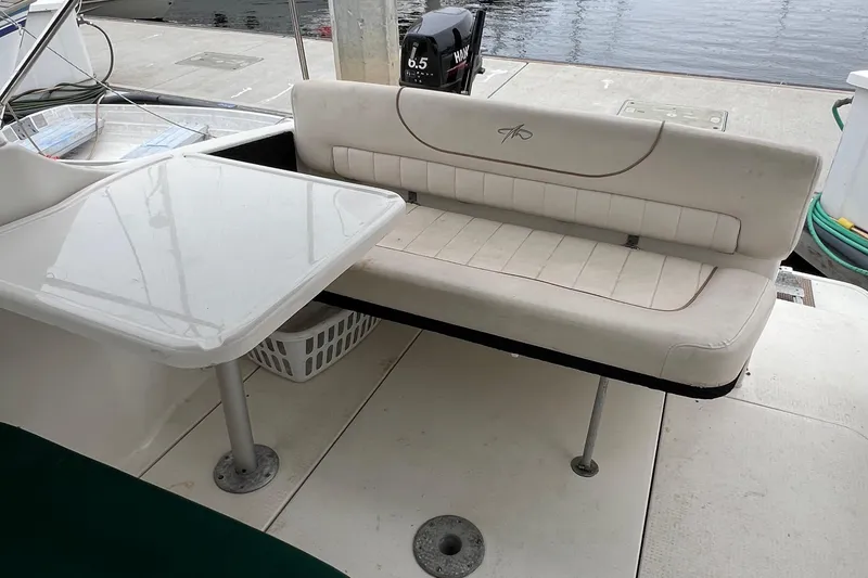 Slide: The Image of 2000 Monterey 302 Cruiser boat interior with seating and table by the dock. - 28