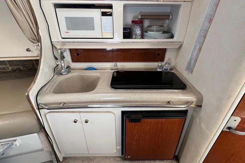 Slide: The Image of Compact kitchen in a 2000 Monterey 302 Cruiser with sink, stove, and microwave. - 31