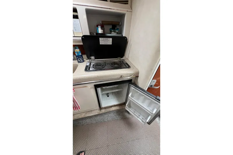 Slide: The Image of Kitchen area in a 2000 Monterey 302 Cruiser with stove and open fridge. - 32