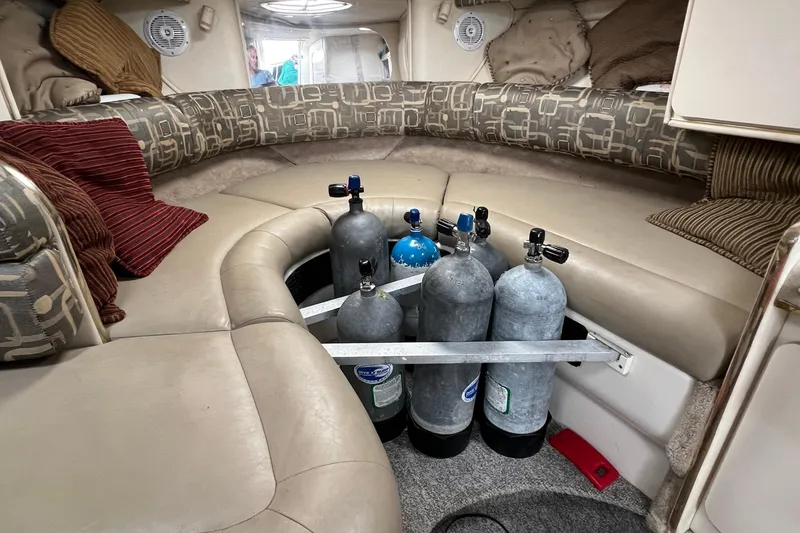 Slide: The Image of Interior of 2000 Monterey 302 Cruiser with scuba tanks and cushioned seating. - 37