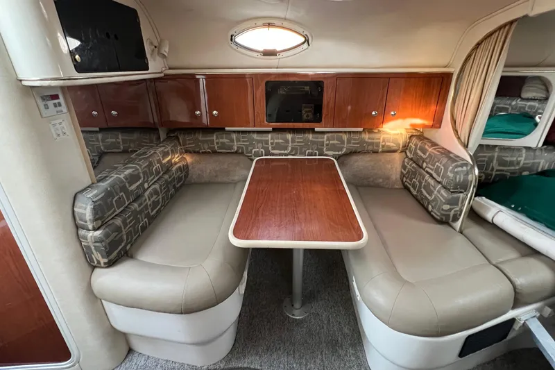 Slide: The Image of 2000 Monterey 302 Cruiser interior with dining area, cushioned seating, and wooden cabinetry. - 39