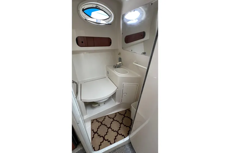 Slide: The Image of Bathroom interior of 2000 Monterey 302 Cruiser with sink, mirror, and porthole window. - 42