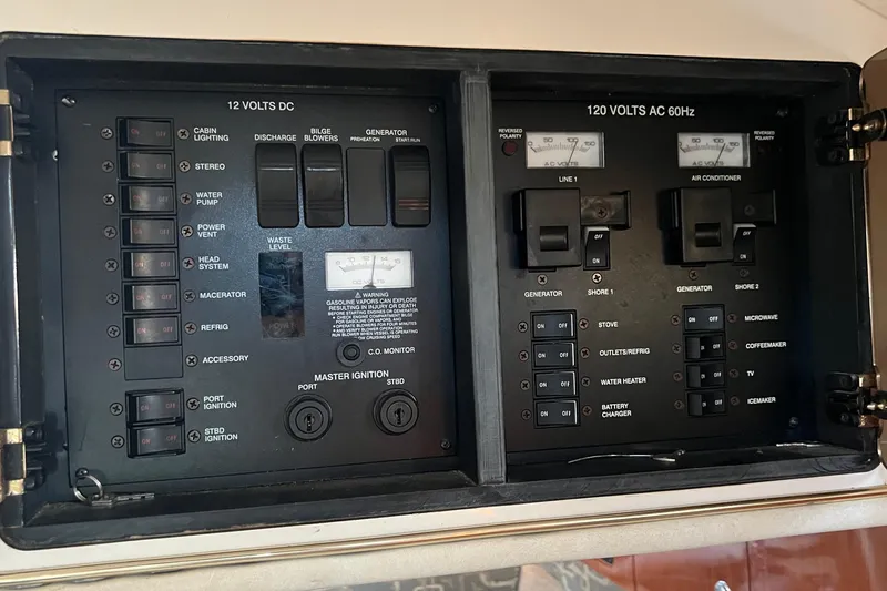 Slide: The Image of Electrical control panel of a 2000 Monterey 302 Cruiser boat, showing switches and meters. - 46