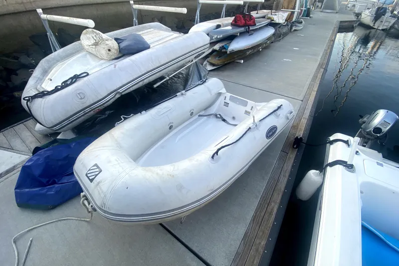 Slide: The Image of Inflatable dinghy docked beside a 2000 Monterey 302 Cruiser at a marina. - 48