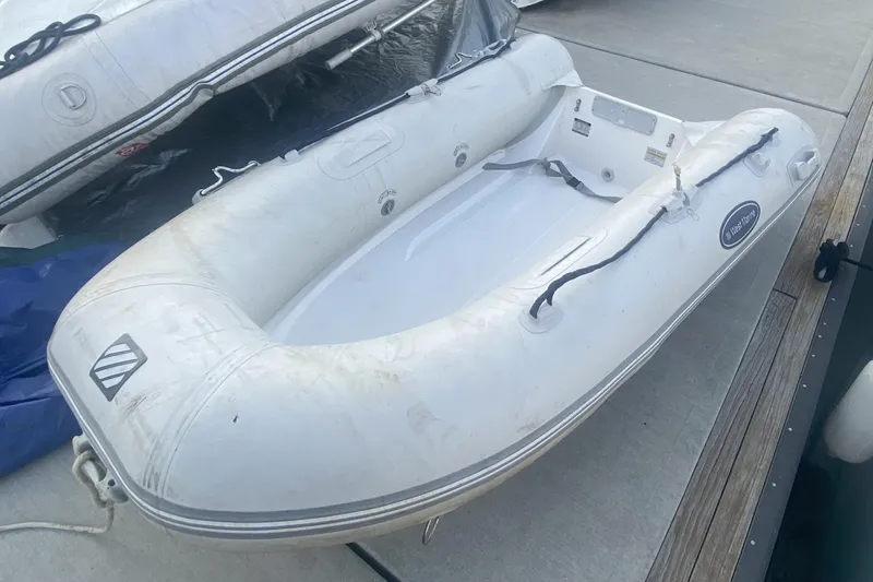 Slide: The Image of White inflatable boat docked, featuring a clean design and sturdy construction. - 49