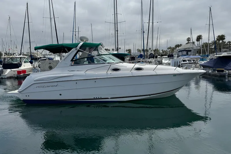 Slide: The Image of 2000 Monterey 302 Cruiser yacht docked in a marina, surrounded by sailboats. - 5