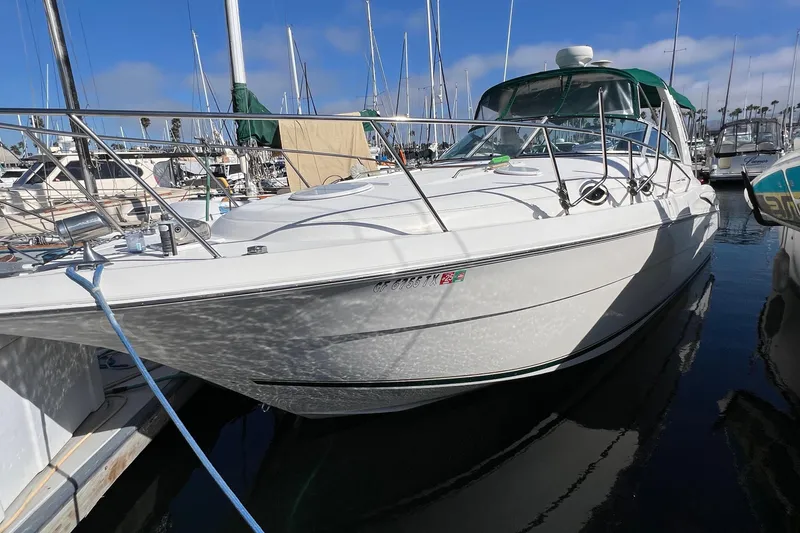 Slide: The Image of 2000 Monterey 302 Cruiser docked at marina, surrounded by sailboats under clear blue sky. - 6