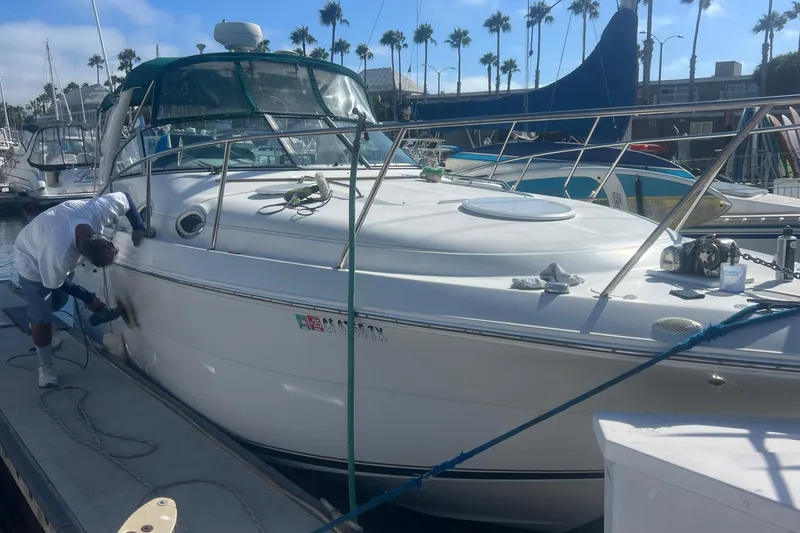 Slide: The Image of Man polishing a 2000 Monterey 302 Cruiser docked at a marina. - 8