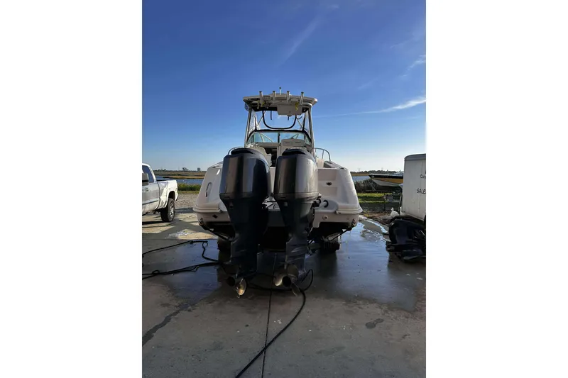 Slide: The Image of 2003 Pro-Line 23 WA boat with dual outboard motors, parked outdoors. - 4