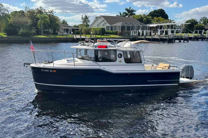 The Image of 2020 Ranger Tugs R-23 boat cruising on a scenic waterway with lush greenery. - 0
