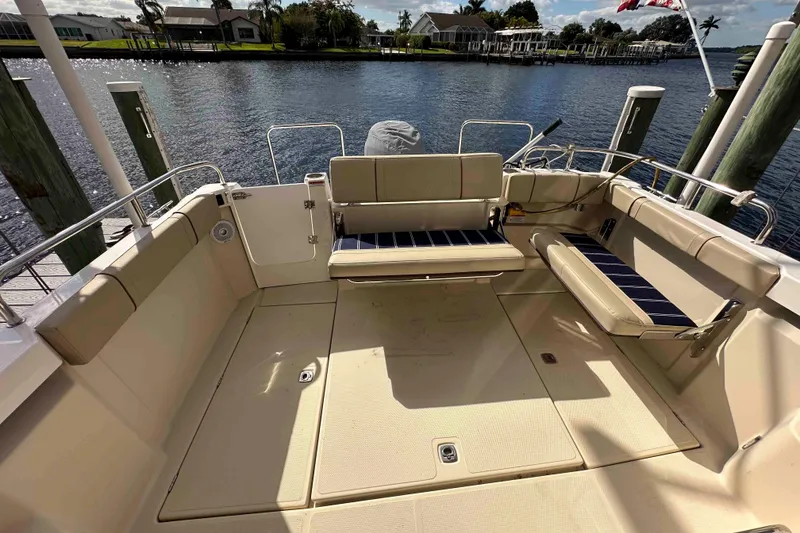 Slide: The Image of 2020 Ranger Tugs R-23 boat interior with seating, docked by the water. - 10