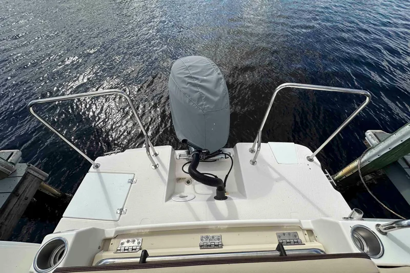 Slide: The Image of 2020 Ranger Tugs R-23 boat stern with covered outboard motor on water. - 14