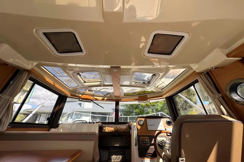 Slide: The Image of Interior view of 2020 Ranger Tugs R-23 boat, featuring helm and panoramic windows. - 15