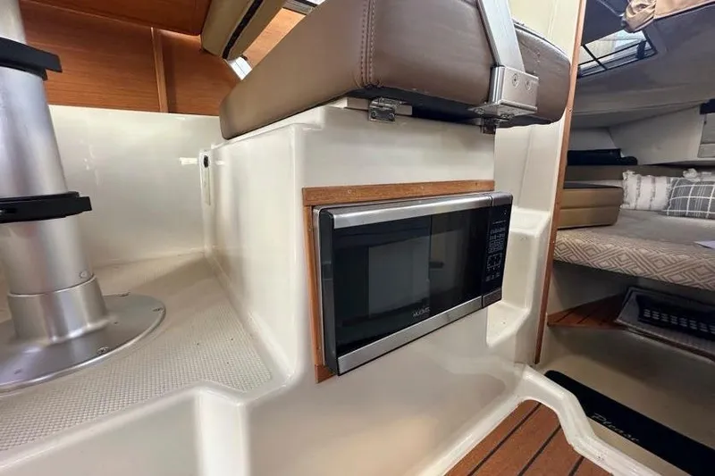 Slide: The Image of 2020 Ranger Tugs R-23 interior with microwave and seating area. - 18