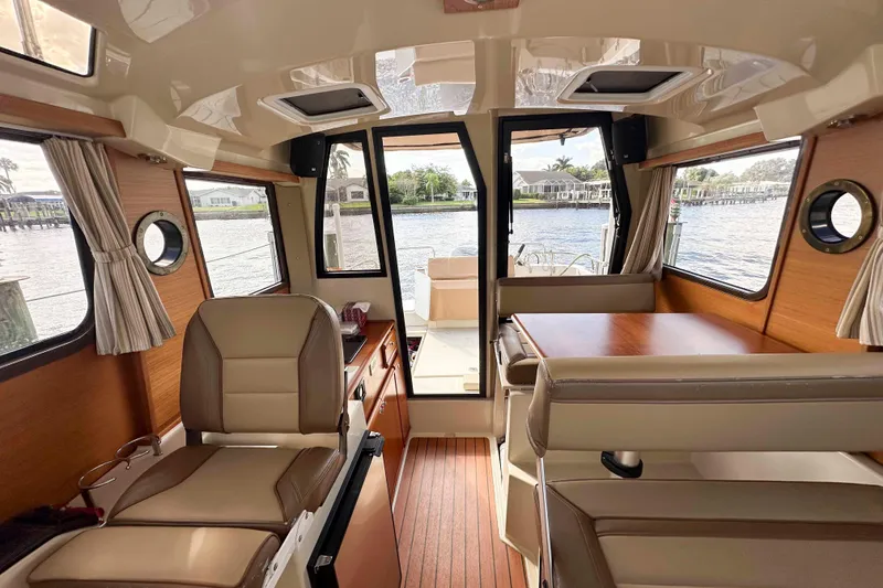 Slide: The Image of Interior of 2020 Ranger Tugs R-23 boat with seating, table, and windows overlooking water. - 20