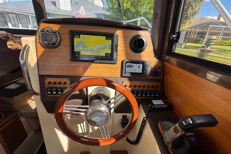 Slide: The Image of 2020 Ranger Tugs R-23 helm with navigation system and wooden steering wheel. - 23